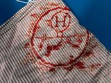 a red and white striped bag with a red smiley face on it