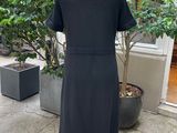 black dress on a mannequin stand in front of a tree