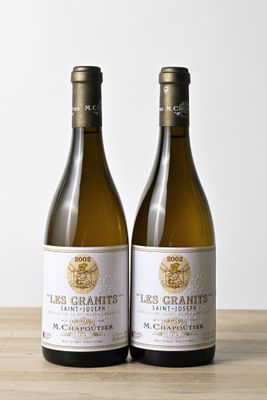 two bottles of white wine sitting on top of a wooden table