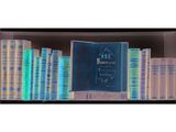 many books on a shelf with a blue cover