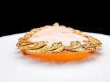 an image of a gold plated broocher with an orange glass center