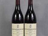 two bottles of wine sitting on top of a table next to each other