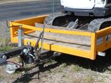 une petite remorque jaune équipée d'une grue