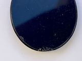 an image of a black round mirror on a white surface