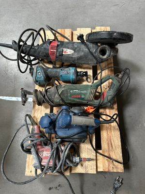 un tas d'outils électriques posés sur une palette au sol