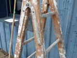 two wooden ladders that are leaning against a building