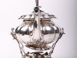 an antique silverplated sugar dish with a spoon on top of it