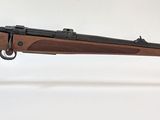 le fusil est posé sur un support transparent, sur une surface blanche