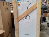 une photo d'un réfrigérateur dans une pièce où se trouvent des cartons et un carton