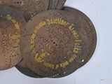 several old rusty metal plates with writing on them on a white surface