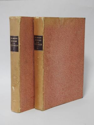 two old books sitting on top of each other on a white surface