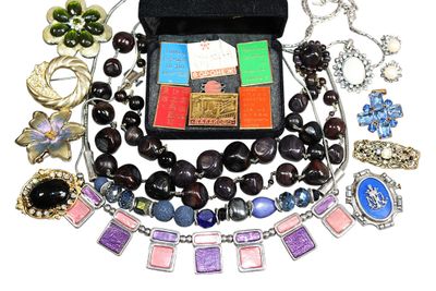 un écrin noir rempli de bijoux variés, posé sur une surface blanche
