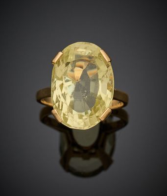 un gros plan d'une bague ornée d'une pierre jaune sur un fond noir