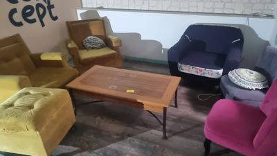 brightly colored chairs and a table in a room with a sign on the wall