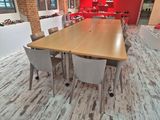 tables and chairs in a room with a red wall and a wooden floor