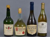 four bottles of wine are lined up in a row on a gray surface