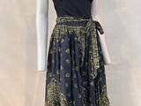 a mannequin wearing a dress with a black top and gold print skirt