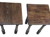 two small wooden stools sitting next to each other on a white surface