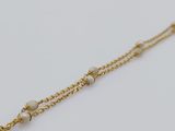 a close up of a gold chain with pearls on it
