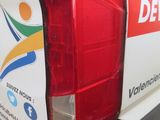 a white van with a red tail light on the back of it
