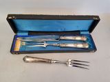 two forks and a knife in a case on a table