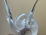 une sculpture en verre représentant un oiseau posé sur une table
