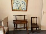a room with a bed, chair, and a painting on the wall