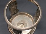 a silver cup that has a bird design on it