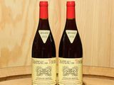 deux bouteilles de vin posées sur un tonneau