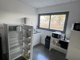 Quelqu'un prend une photo d'une cuisine vide où se trouve un réfrigérateur