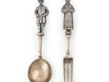 deux cuillères et une fourchette surmontées d'une statuette