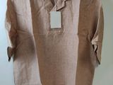 une chemise beige avec une étiquette suspendue à un cintre accroché au mur