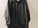 une veste noire suspendue à un cintre accroché au mur