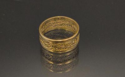 a gold ring sitting on top of a black surface