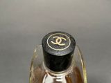 a bottle of perfume with a gold logo on it