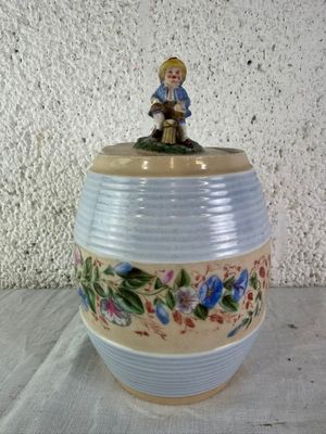 a small figurine sitting on top of a vase