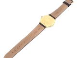 a close up of a watch on a white surface with a white background
