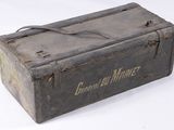 an old metal box that is sitting on a white surface