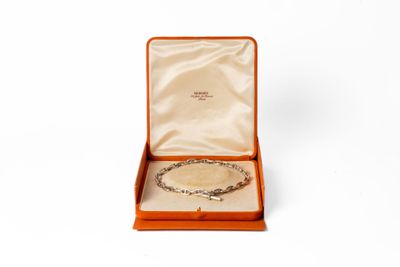 une boîte ouverte contenant un bracelet, posée sur une surface blanche