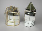 two small glass terrariums with mirrors on a white surface