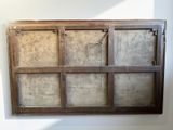 an old window with a wooden frame hanging on the wall