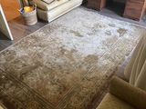 a living room with a couch, chair and a rug on the floor