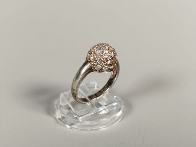 un gros plan d'une bague en diamant posée sur un socle transparent