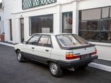 a small white car parked in front of a building