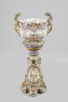un vase richement décoré posé sur un socle en bois