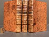 two old books sitting on top of each other on top of a table
