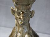 a brown vase with a gold decoration on the top of it