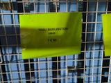 two yellow signs on a wire fence with a blue building in the background