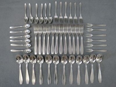 de nombreuses cuillères et fourchettes en argent disposées sur une table