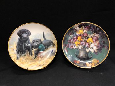 deux assiettes ornées de chiens et de fleurs sur fond noir